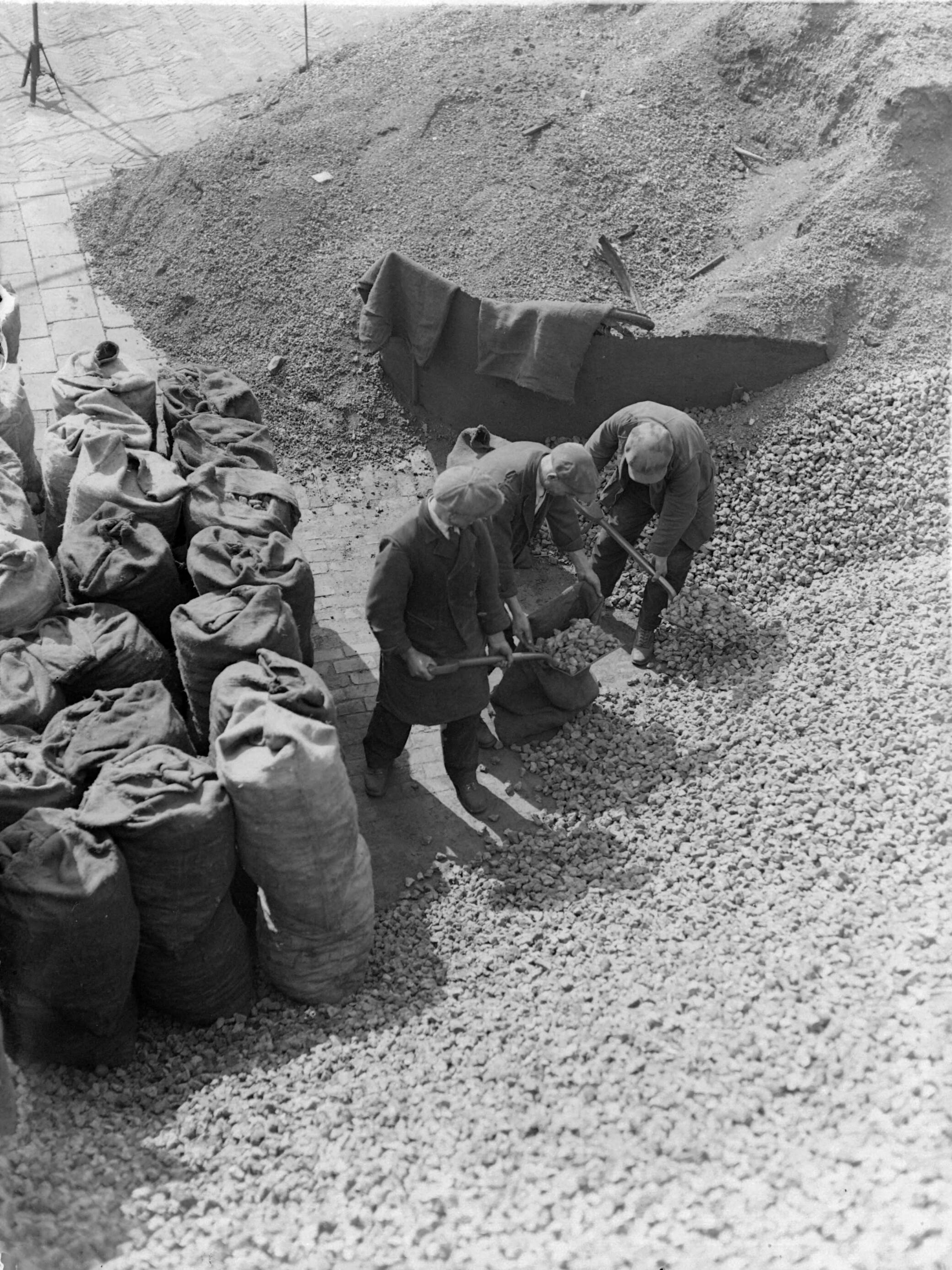 Mannen scheppen steenkool in zakken, http://hdl.handle.net/10648/ae9aa6da-d0b4-102d-bcf8-003048976d84