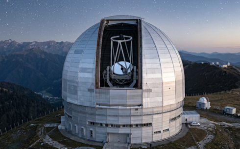 Een voorbeeld van een grote professionele optische telescoop in een observatoriumkoepel op een berg.