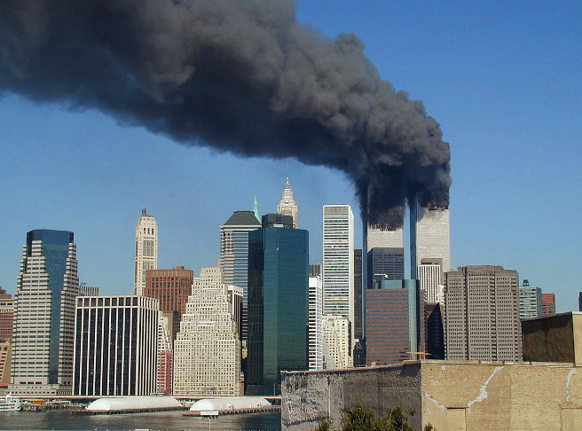 WTC smoking on 9-11 door Michael Foran via: https://commons.wikimedia.org/wiki/File:WTC_smoking_on_9-11.jpeggelicenseerd onder CC BY 4.0 (https://creativecommons.org/licenses/by/4.0/).
