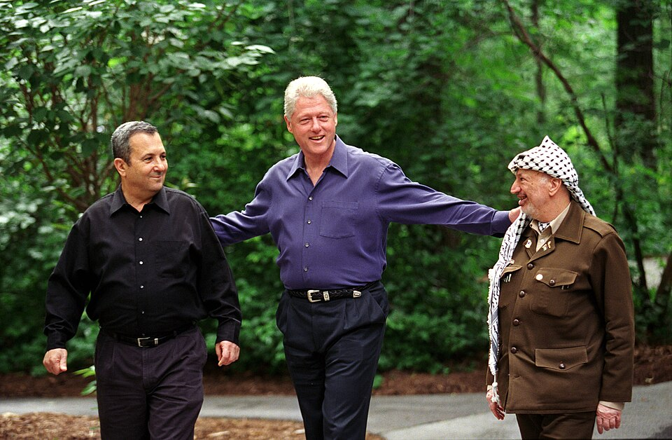 Ehud Barak (Israël), Bill Clinton (VS), Yasser Arafat (Palestina), https://commons.wikimedia.org/wiki/File:President_Bill_Clinton_walks_with_Prime_Minister_Ehud_Barak_of_Israel_and_Yasser_Arafat_of_the_Palestinian_Authority.jpg