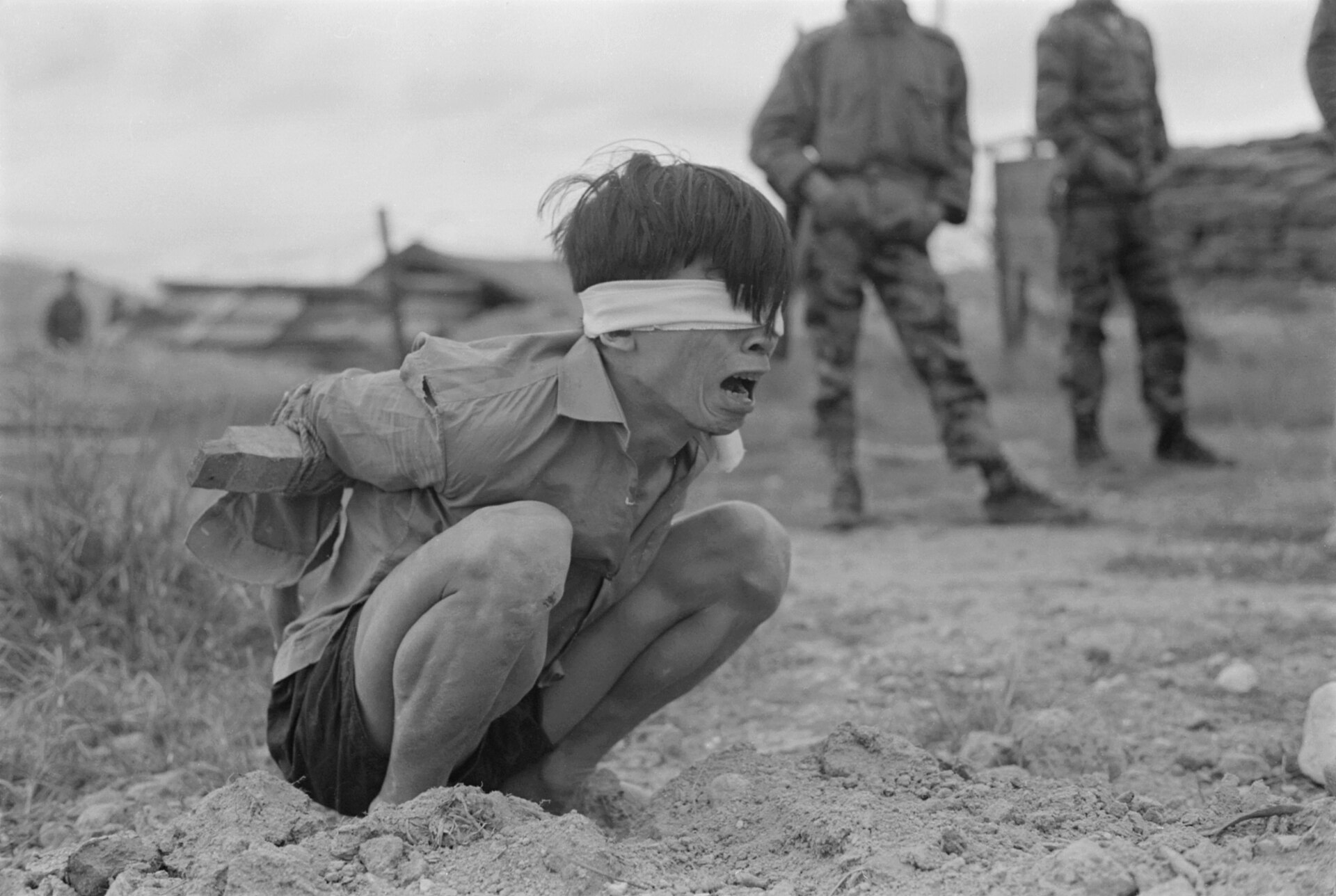 Vietnamese gevangene wacht op ondervraging door de Amerikaanse Special Forces in Thuong Duc, https://commons.wikimedia.org/wiki/File:Thuong_Duc,_Vietnam_-_A_Viet_Cong_prisoner_awaits_interrogation_at_the_A-109_Special_Forces_Detachment_in_Thuong_-_NARA_-_531447.jpg