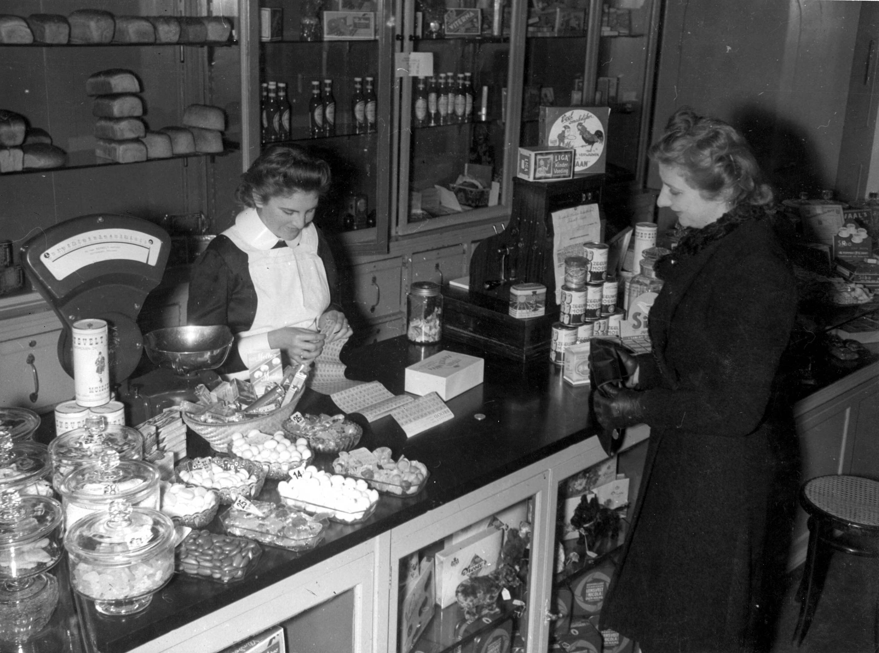 Vrouw koopt voedsel op de bon, http://hdl.handle.net/10648/35429da5-bccf-a382-e063-6df0900a6686.