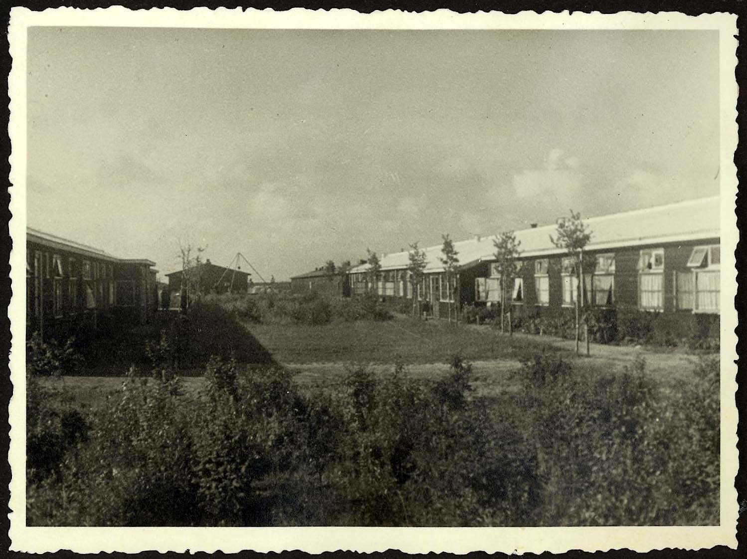 Foto van de barrackken van Westerbork, https://commons.wikimedia.org/wiki/File:Westerbork,_Holland,_A_garden_between_camp_barracks.jpg